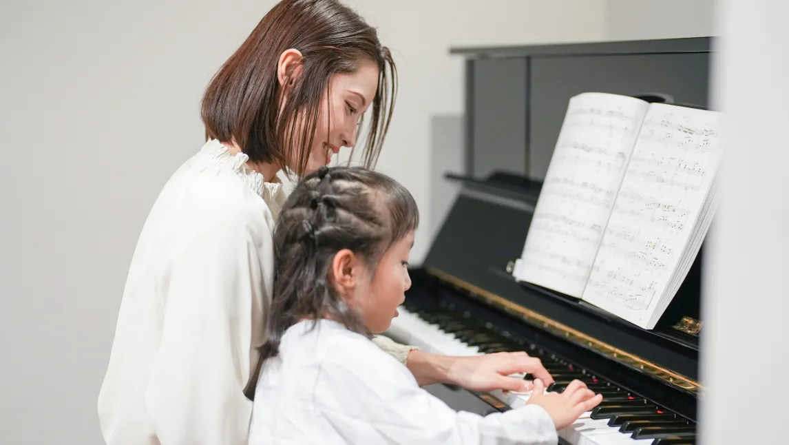 子どもにピアノを教えている様子